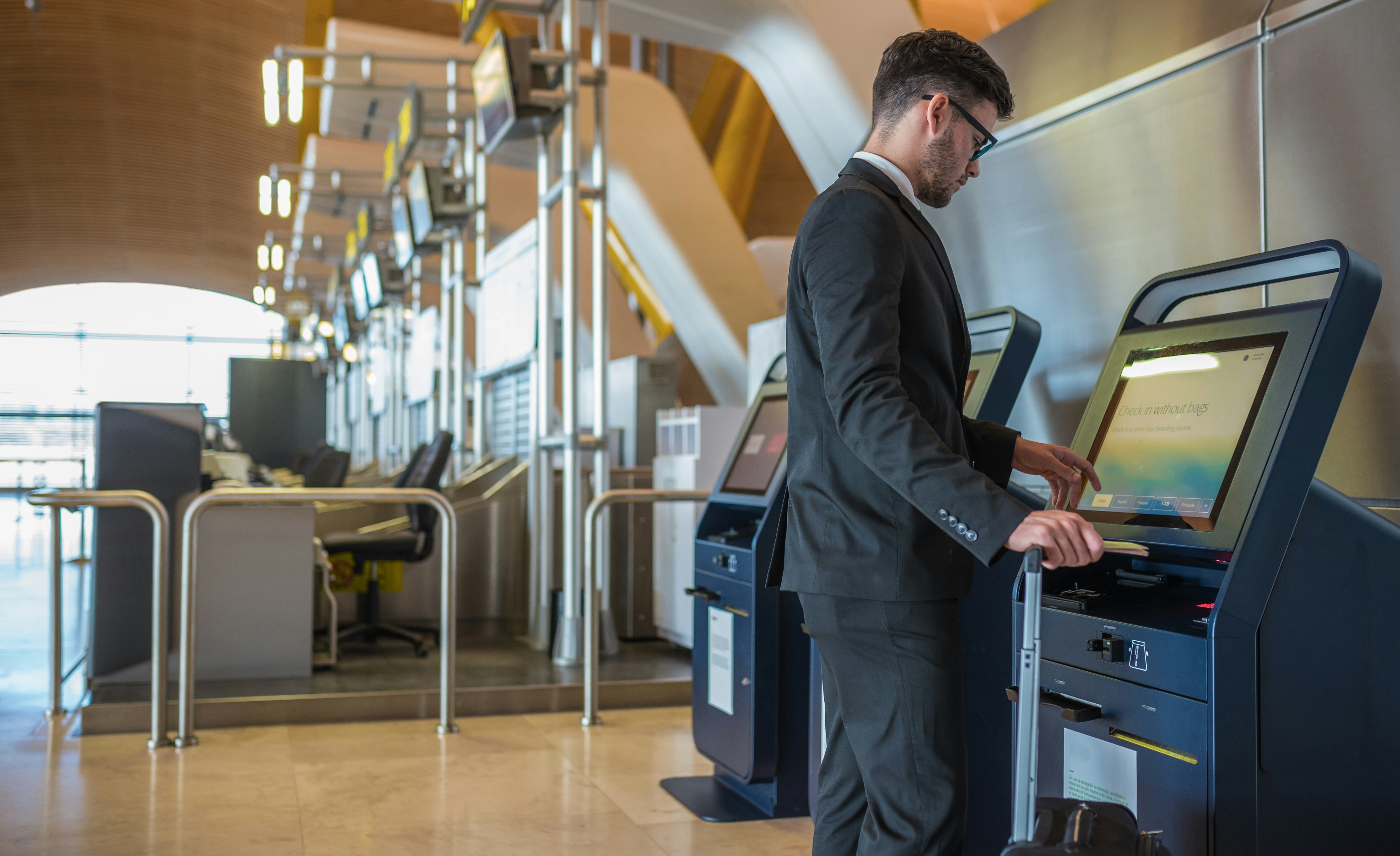 Person at the airport, checking-in by using a self-service terminal